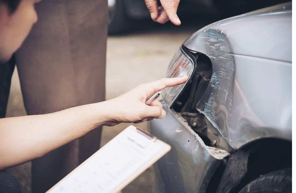 an insurance investigator looking at the car that has been in a car crash